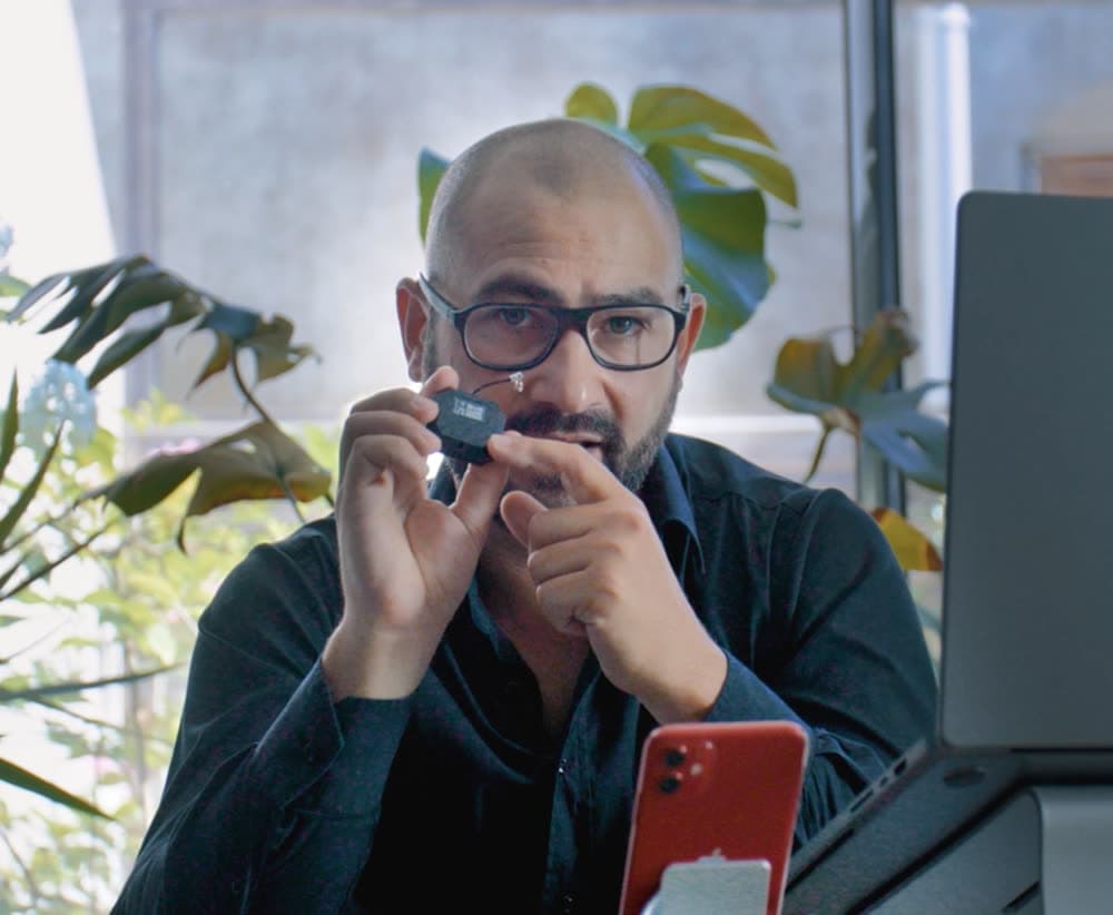 Le badge Smart Ruby tenu en main devant un bureau